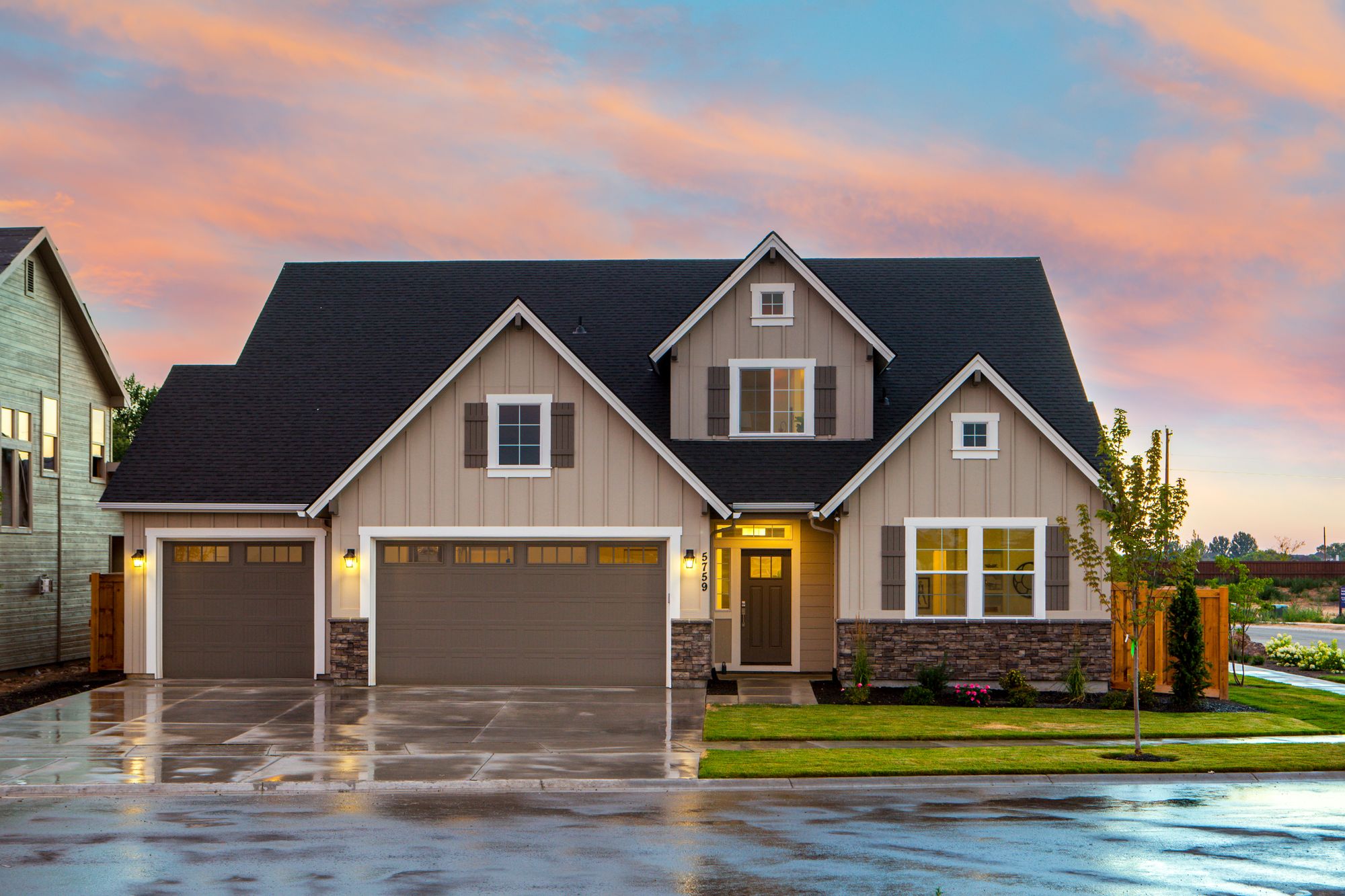 Front-yard lawn, shrubs, and planting beds beside a concrete driveway